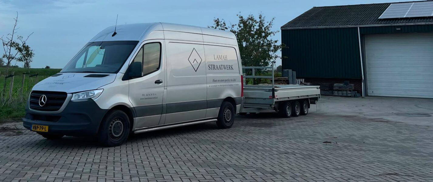 Bedrijfsbus van Lamah Straatwerk met aanhanger
