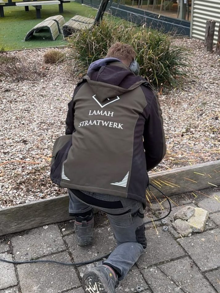 Medewerker van Lamah Straatwerk aan het werk in tuin
